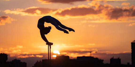 Gymnast Balancing before a city skyline