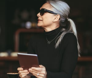 Female professional in black turtleneck holding a tablet